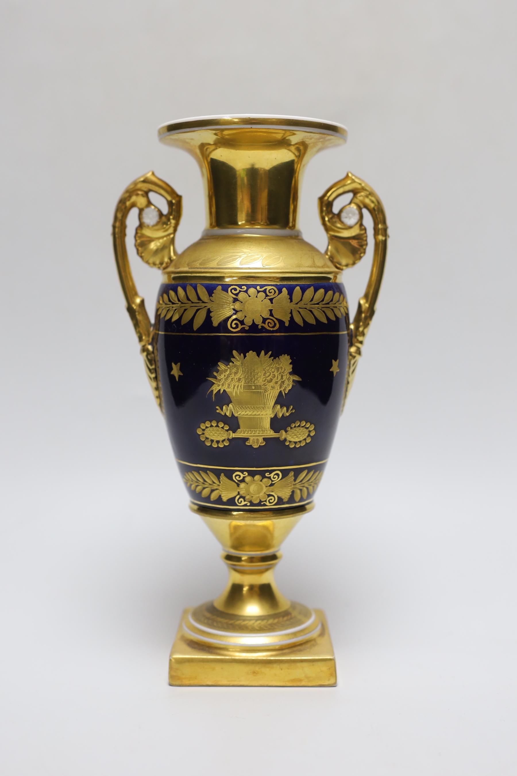 A fine Paris porcelain vase with two handles, highly gilded, the blue ground with a basket of flowers on each side, 23.5cm tall